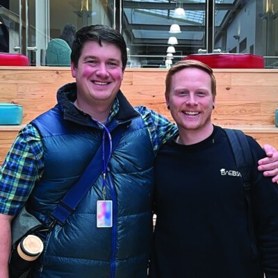 Two navigator men, who lead the Austin Community College ministry, stand next to each other infront of a large staircase.
